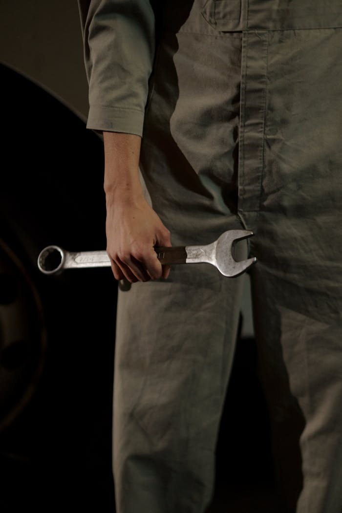 gallery-02 Close-up of an auto mechanic holding a wrench in a workshop setting.
